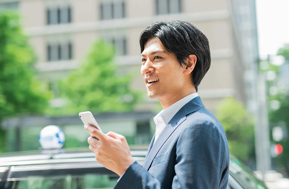 Un homme appelle un taxi avec son smartphone dans la main